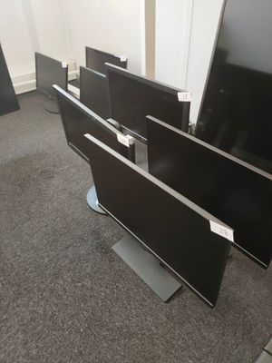 several flat screen televisions sitting on top of each other in a room