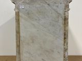 a marble tombstone on a wooden table with a white wall in the background