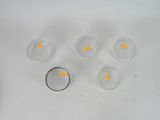 six glasses of water with orange spots on them on a white surface