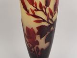 a vase with a red flower on it sitting on a table