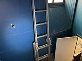 une échelle appuyée contre un mur bleu dans une pièce