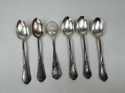 six spoons are lined up in a row on a table