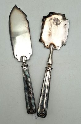 two silver spoons and a knife on a white surface