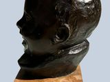 bronze bust of a young boy on a marble base