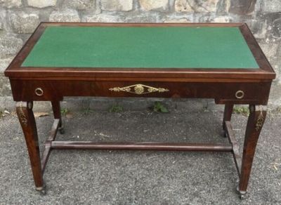 a small table with a green top sitting on a sidewalk