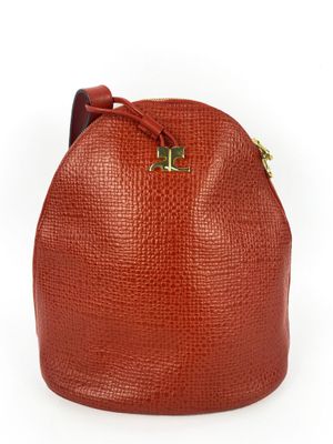 un sac seau en cuir rouge avec des finitions dorées sur la poignée