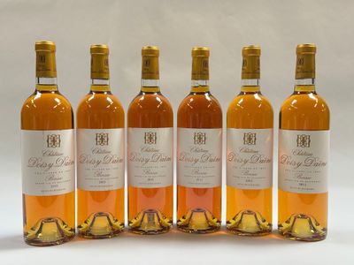quatre bouteilles de vin sont alignées sur une surface blanche
