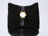 un petit sac noir orné d'une montre en or