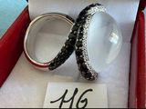 paire de bagues ornées de diamants noirs et blancs, présentée dans un coffret rouge
