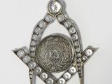 an image of a masonic symbol with a coin in the center