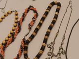 many necklaces and bracelets laid out on a table