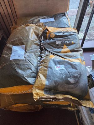 a bed that has a lot of bags on top of it