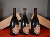 three bottles of wine sitting next to a wooden box on a table