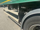 a green semi truck with a yellow stripe on the side