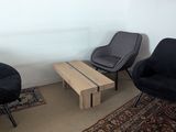 three chairs and a coffee table in a small room