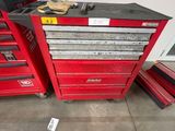 un groupe de caisses à outils rouges posées sur le sol d'un garage