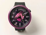 une montre noire et rose posée sur une surface blanche