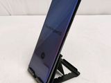 a close up of a cell phone on a stand on a white surface
