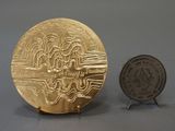 a gold coin next to a silver coin on a table