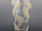 a glass vase with a pattern of leaves on it