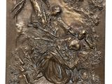 a bronze plaque depicting a woman and birds in a forest