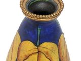 a blue vase with a yellow leaf on it