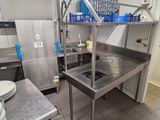 a large stainless steel kitchen with a sink and a stove