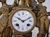 a clock that has a statue on top of it