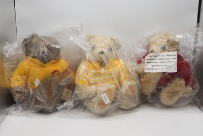 quatre oursons en peluche emballés dans des sacs en plastique, posés sur une étagère