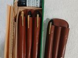 une boîte de stylos et deux étuis en cuir