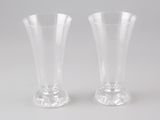 une paire de vases en verre transparent posés sur une table blanche