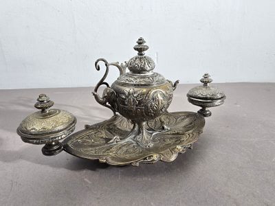 un plateau en argent posé sur une table, sur lequel se trouve une théière