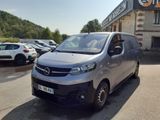 une camionnette argentée garée devant un immeuble