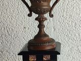 a bronze trophy sitting on top of a black box