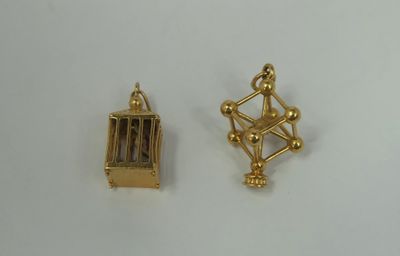 two pieces of gold plated metal with a cage on top of it
