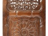 a carved wooden panel with a floral design on it