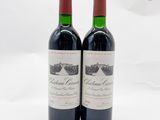 deux bouteilles de vin rouge posées l'une à côté de l'autre sur une surface blanche