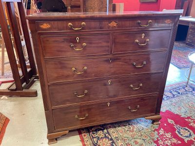 une commode marron avec de nombreux tiroirs, dans une pièce