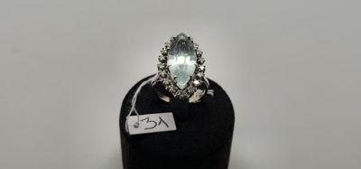 une bague ovale sertie d'une aigue-marine et de diamants, posée sur un socle noir