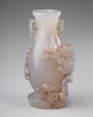 un vase blanc avec des fleurs posé sur une table