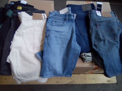 plusieurs paires de jeans posées sur une boîte en carton