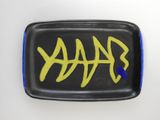 a black plate with a yellow fish on it