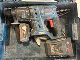 a tool box with a drill and two batteries in it