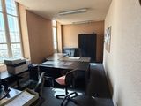 a desk with a computer and a chair in a room