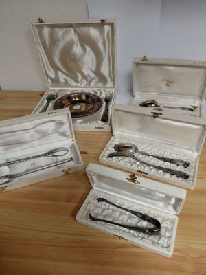 five silverware items in a case on a wooden table