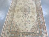 Il y a un vieux tapis par terre dans une pièce.