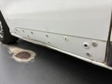 a white car with holes on the side of it