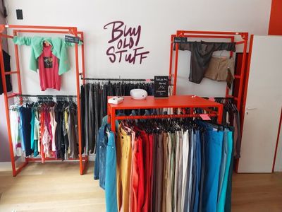 un présentoir de vêtements dans un magasin de mode avec une étagère rouge
