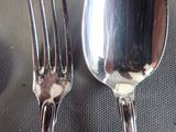 two forks and a spoon sitting on a table