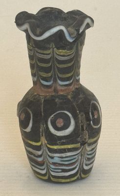 un vase noir orné d'un motif, posé sur une table